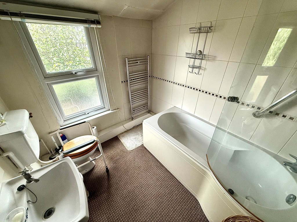 Lot: 76 - TWO-BEDROOM MID-TERRACE HOUSE FOR IMPROVEMENT - Bathroom with shower over bath, toilet, sink and window